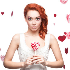 surprised red-haired woman holding lollipop