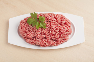Minced meat over wooden background
