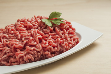 Minced meat over wooden background