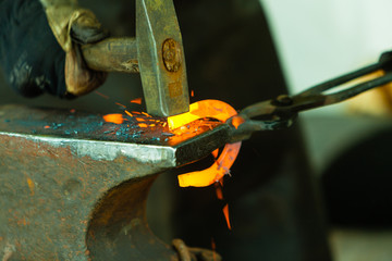 Hammering glowing steel - to strike while the iron is hot.