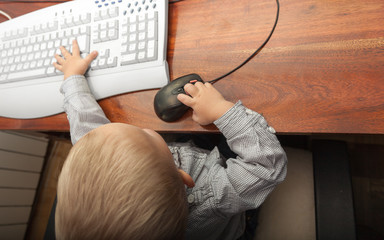 Fototapeta na wymiar Little boy child kid playing on the computer