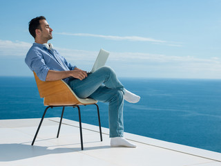 relaxed young man at home on balcony