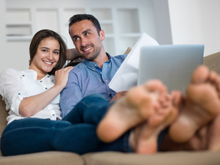 relaxed young couple working on laptop computer at home