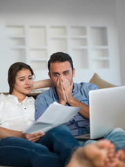 relaxed young couple working on laptop computer at home