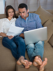 relaxed young couple working on laptop computer at home