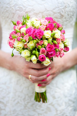 Closeup view of a bride holding bouquet of roses