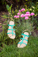 Green sandals lie on the grass, ladies comfortable shoes