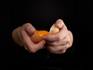 Hands breaking an egg.