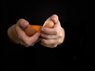 Hands breaking an egg.