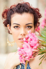 Confident young woman close up portrait with flower.