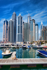 Dubai Marina with boat against skyscrapers in Dubai, UAE