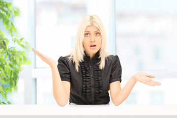 Fototapeta premium Woman gesturing uncertainty seated at home