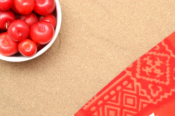 Red plums on sand on summer