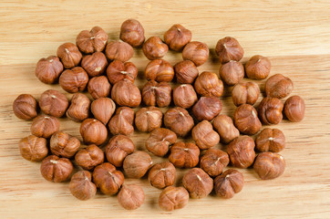 toasted hazelnuts without shells, on wood, background