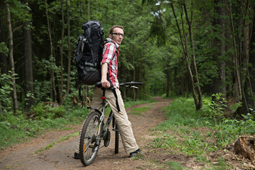 Naklejka premium The man, waiting for friends on a country road in the forest.
