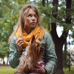 Sad girl with dog waiting boyfriend in city park