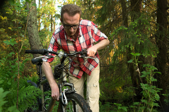 Tourist, repearing his bike in the woods