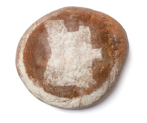 A loaf of fresh bread covered with rye flour in the shape of Ang
