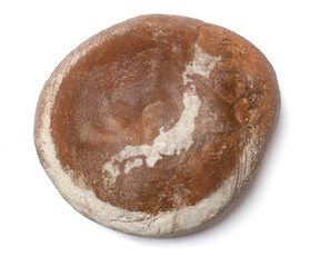 A loaf of fresh bread covered with rye flour in the shape of Jap