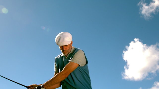 Handsome golfer swinging his club