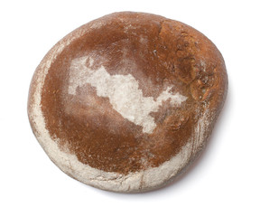 A loaf of fresh bread covered with rye flour in the shape of Uzb