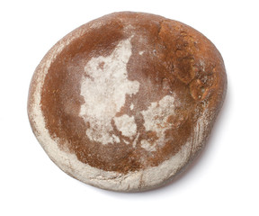 A loaf of fresh bread covered with rye flour in the shape of Den