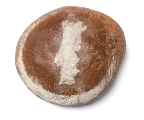 A loaf of fresh bread covered with rye flour in the shape of Por