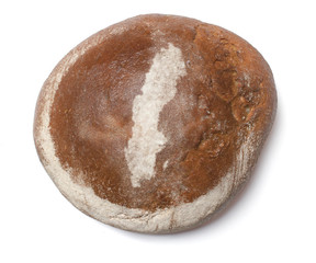 A loaf of fresh bread covered with rye flour in the shape of Swe