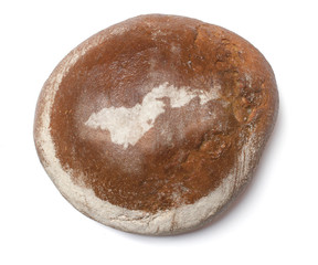 A loaf of fresh bread covered with rye flour in the shape of Ame