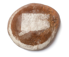 A loaf of fresh bread covered with rye flour in the shape of Con