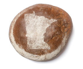 A loaf of fresh bread covered with rye flour in the shape of Min
