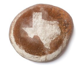 A loaf of fresh bread covered with rye flour in the shape of Tex