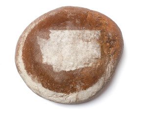 A loaf of fresh bread covered with rye flour in the shape of Was