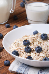 Oatmeal with blueberries and milk close-up vertical