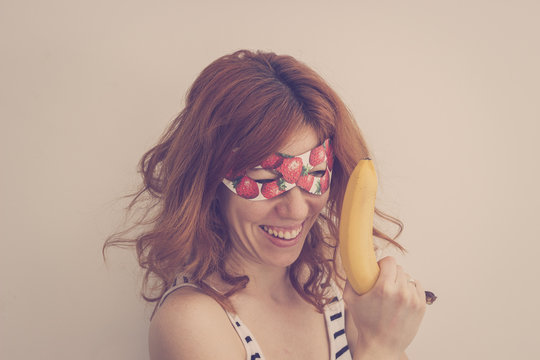 Superhero hipster girl wearing mask with banana gun