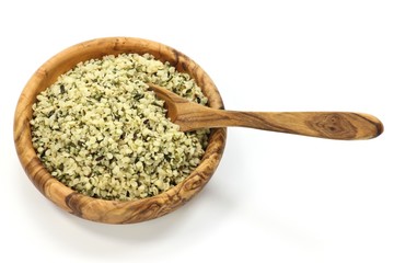 Hanfsamen in einer Schale aus Olivenholz isoliert auf weißem Hintergrund