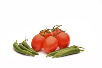 Green chili peppers with red tomatoes on the white background