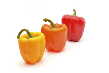 Red, orange and yellow capsicum on a white background