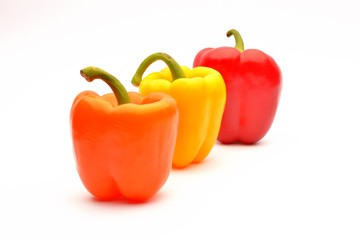 Red, orange and yellow capsicum on a white background