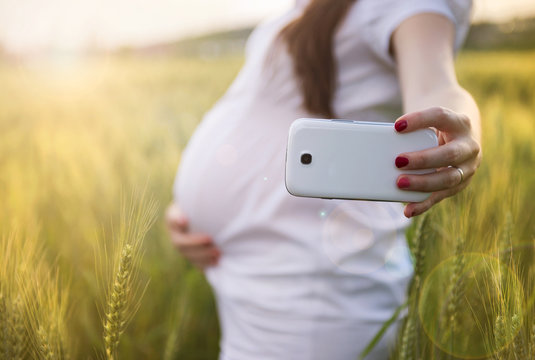 Pregnant woman taking selfie