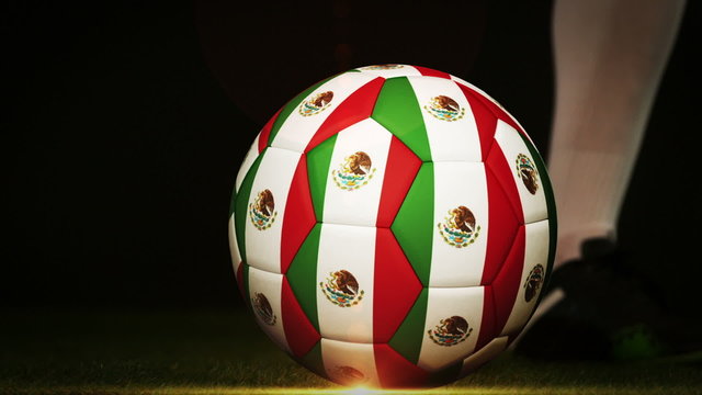 Football player kicking mexico flag ball