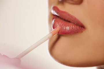 woman's lips and lip gloss applying - obrazy, fototapety, plakaty