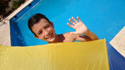 Niño saludando en la piscina