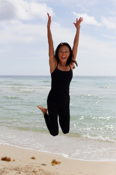 Stock image happy woman leaping with arms outstretched