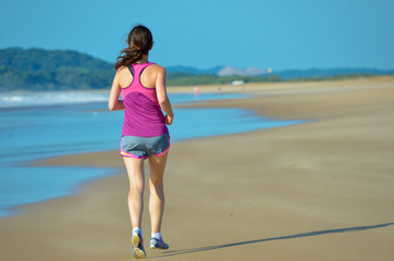 Woman running on beach, girl runner jogging outdoors