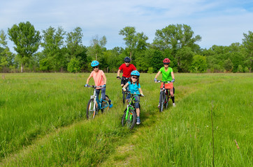 Happy family on bikes, cycling with kids
