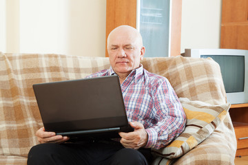 gray-haired man working at his laptop