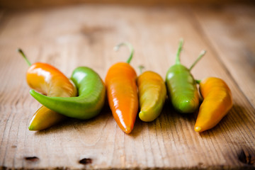 Raw pods hot peppers on a wooden background