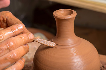 hands of a potter, creating an earthen jar