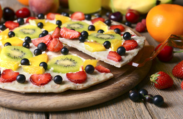 Sweet pizza with fruits on table close-up
